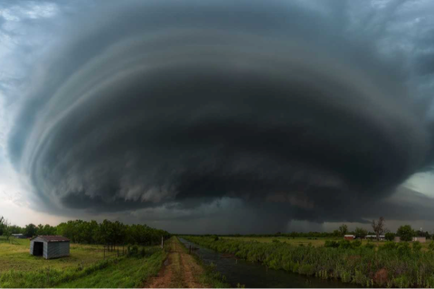A large supercell forms in the sky. The sky is grey and ominous.