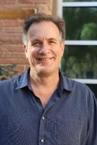 Portrait of a man in a blue shirt with short brown hair